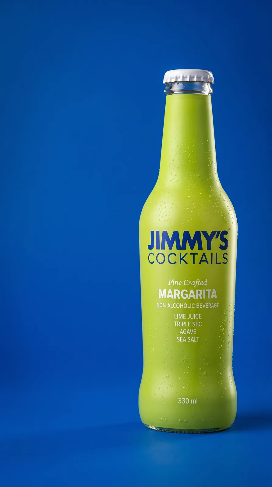 Jimmy's Cocktails margarita bottle, studio shot on cobalt